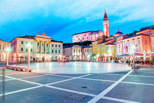 Obraz na płótnie Beautiful amazing city scenery in the central square with the old clock tower in Piran, the tourist center of Slovenia in the light of lanterns. popular tourist attraction. Wonderful exciting places. w salonie