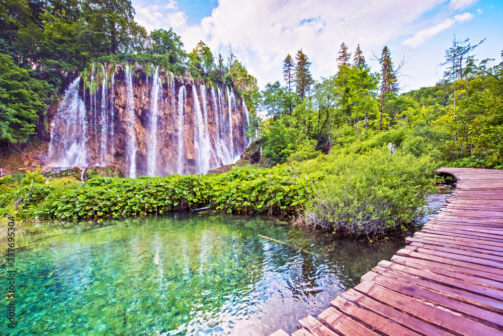 Fototapeta premium Niesamowicie piękny bajeczny magiczny krajobraz z mostem w pobliżu wodospadu w Plitvicach w Chorwacji (medytacja harmonii, antystres - koncept)