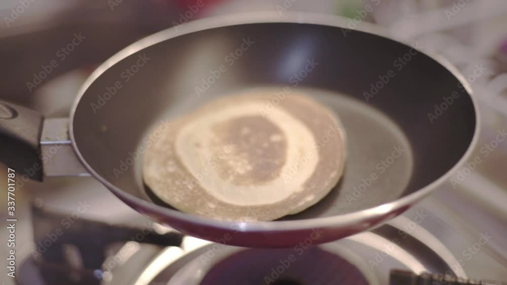 Shaking pan with cooked pancake to cool down closeup Shaking pan with cooked pancake to cool down closeup