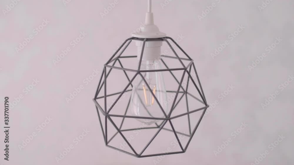 Geometric lamp shade bulb turning off closeup
