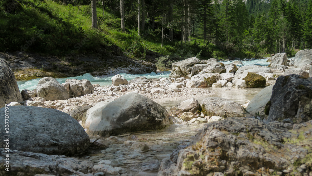 Rapid river flowing through the valley in the Italian Dolomites Rapid river flowing through the valley in the Italian Dolomites