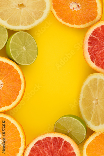 Citrus frame. Citrus Fruits mix flat lay including lemon, lime, grapefruit and orange on a yellow background. Copy space. Vitamins boom. Whole and sliced citrus fruit. Fruit background. Antioxidant .
