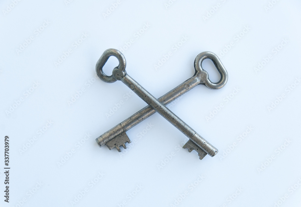 Two crossed retro keys isolated on white background. Top view Two crossed retro keys isolated on white background. Top view
