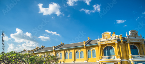 The old Neoclassical shophouses on the front of Tha Chang Pier (Bangkok, Thailand). Yellow retro european style building with beautiful blue sky.