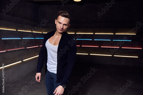 man against the background of neon lights in a white t-shirt casual posing