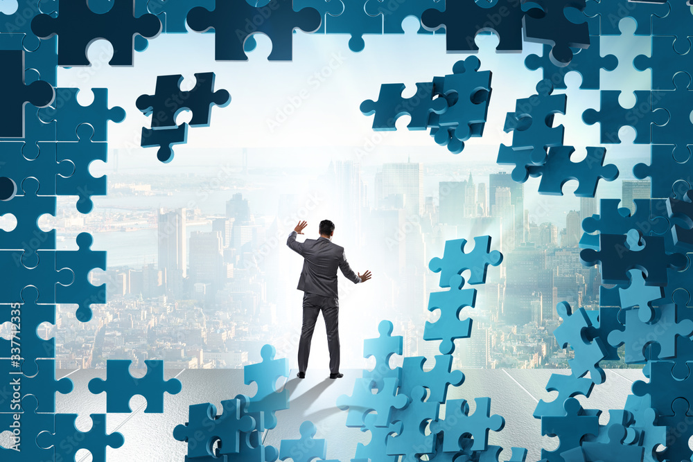 Businessman breaking the wall of jigsaw puzzle Businessman breaking the wall of jigsaw puzzle