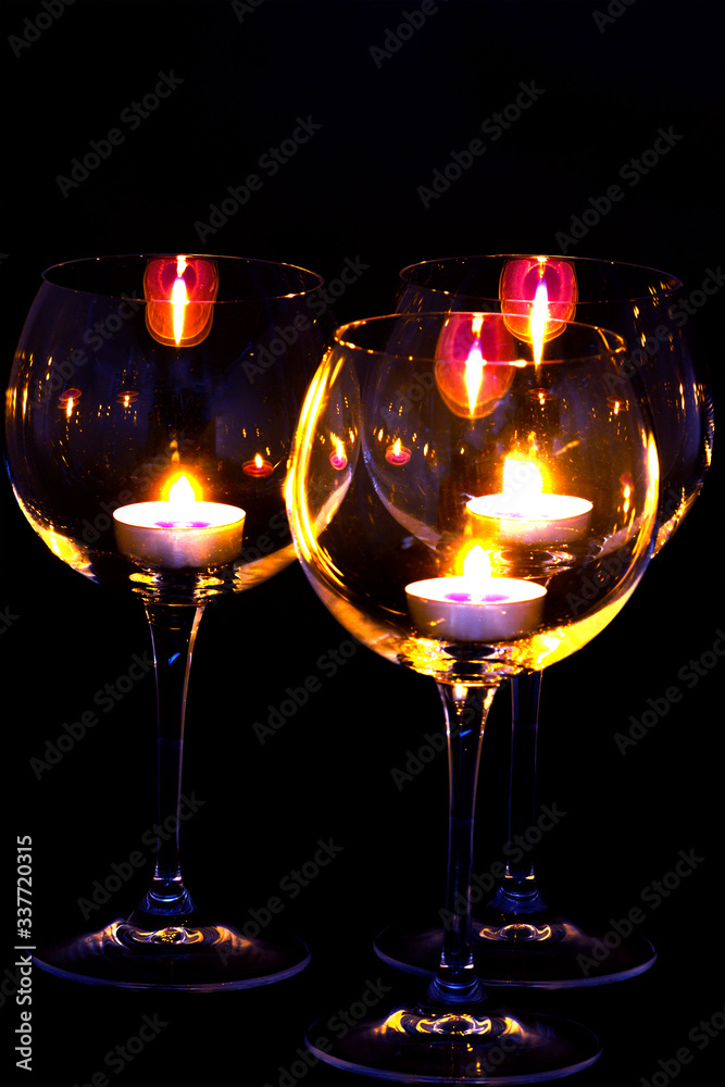 three candels tealights in wine glasses