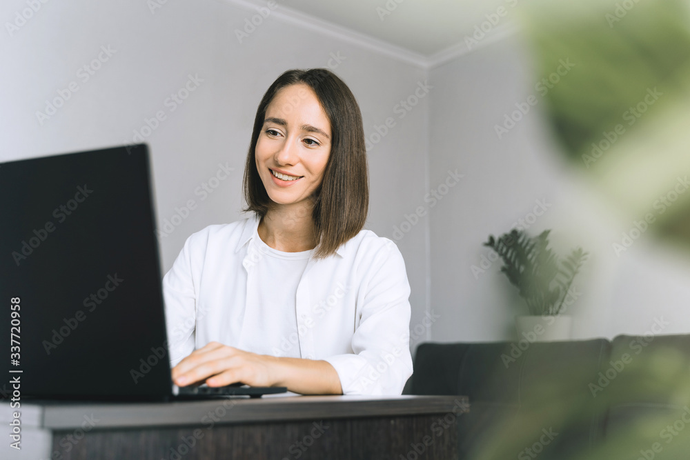 Happy young business woman or student with using laptop at the home office. Frelance work from home in quarantine concept. Happy young business woman or student with using laptop at the home office. Frelance work from home in quarantine concept.