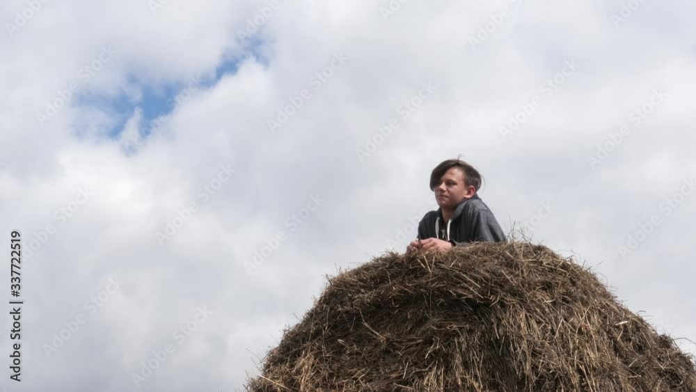 teenager lies in a straw against the sky teenager lies in a straw against the sky
