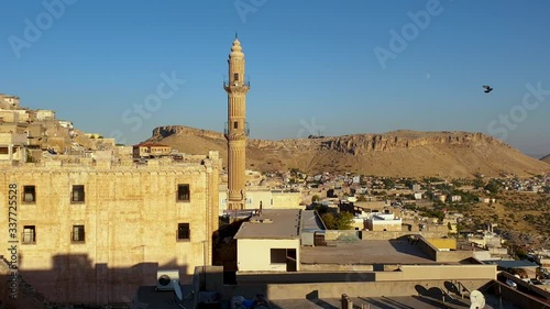 Mardin, Turkey - January 2020: Sehidiye mosque and its minaret with old Mardin cityscape photo