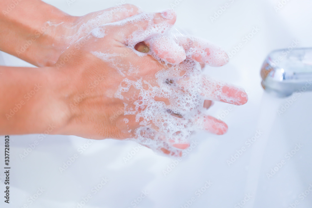 young women washing hands with soap rubbing fingers young women washing hands with soap rubbing fingers