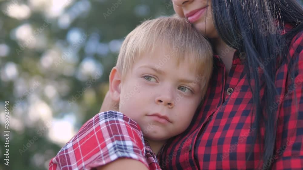 happy family mom and son sad child concept. mom tender childhood video. slow motion video. a mom brunette girl protects caress gently hugs takes care lifestyle of the son blonde boy outdoors happy family mom and son sad child concept. mom tender childhood video. slow motion video. a mom brunette girl protects caress gently hugs takes care lifestyle of the son blonde boy outdoors