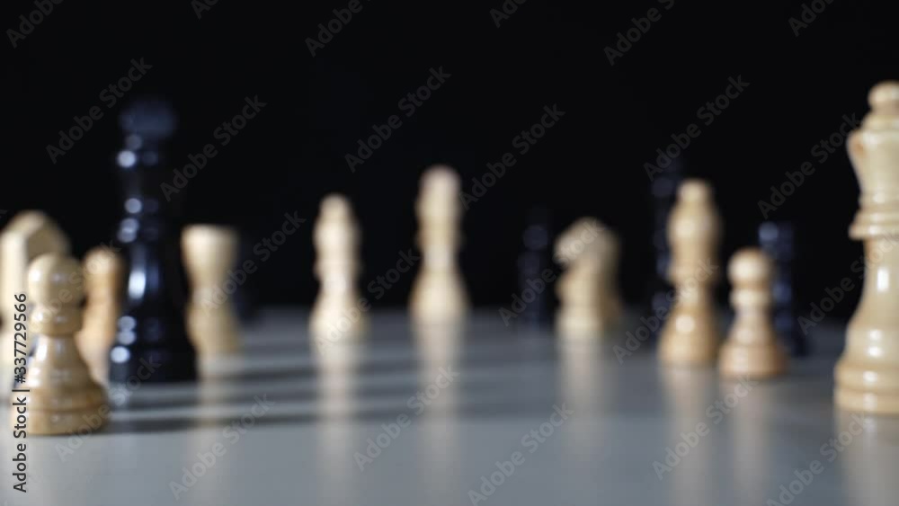 Chess pieces on table with camera moving dolly shot toward white King in the end on black screen, leadership concept Chess pieces on table with camera moving dolly shot toward white King in the end on black screen, leadership concept