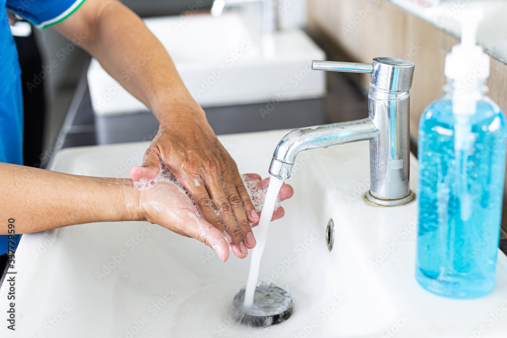 Man is washing his hands in a sink sanitizing the colona virus for sanitation and reducing the spread of COVID-19 spreading throughout the world, Hygiene ,Sanitation concept.