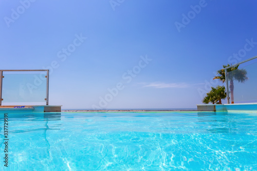 Luxury swimming pool and blue water at the resort with beautiful sea view.  © sergojpg
