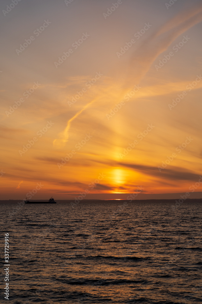 Cargo ship silhouette at Sunset in Oresund between Helsingor, Denmark and Helsingborg, Sweden. Cargo ship silhouette at Sunset in Oresund between Helsingor, Denmark and Helsingborg, Sweden.