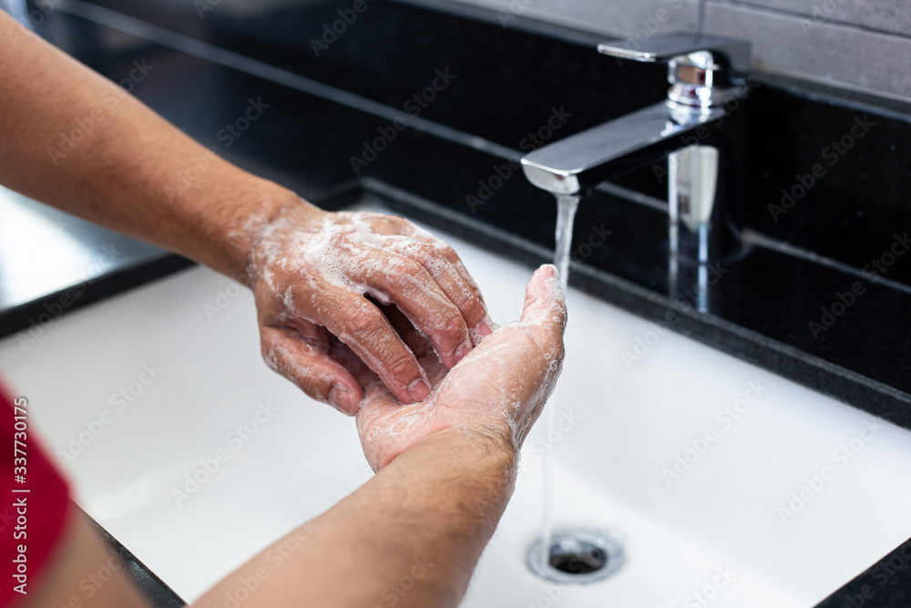 Man is washing his hands in a sink sanitizing the colona virus for sanitation and reducing the spread of COVID-19 spreading throughout the world, Hygiene ,Sanitation concept.