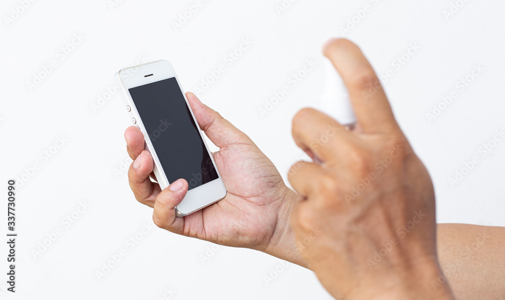 Men use alcohol spray to get rid of bacteria and viruses on mobile phones, Inhibition and prevention of Covid-19 virus infection using 70 percent alcohol, protect virus concept. Men use alcohol spray to get rid of bacteria and viruses on mobile phones, Inhibition and prevention of Covid-19 virus infection using 70 percent alcohol, protect virus concept.