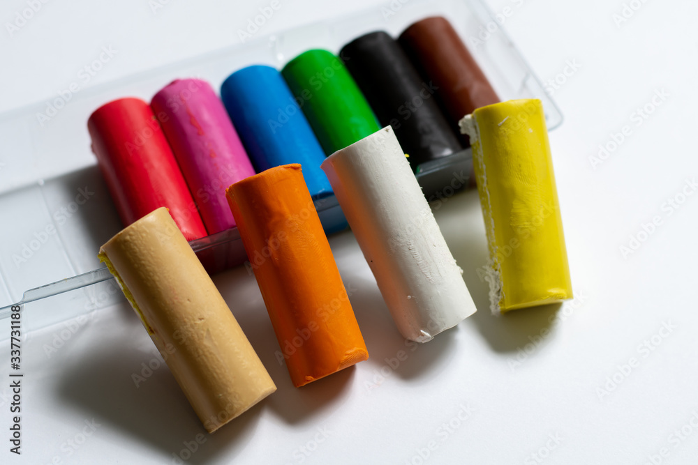 many multi-colored plasticine sticks lie on a white background. isolate. for children's creativity many multi-colored plasticine sticks lie on a white background. isolate. for children's creativity