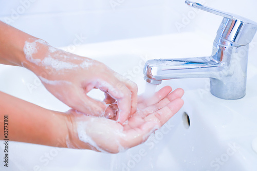 Close-up of young women washing hands with soap rubbing fingers and skin under faucet water flows on white basin for pandemic prevention Corona virus, Covid-19