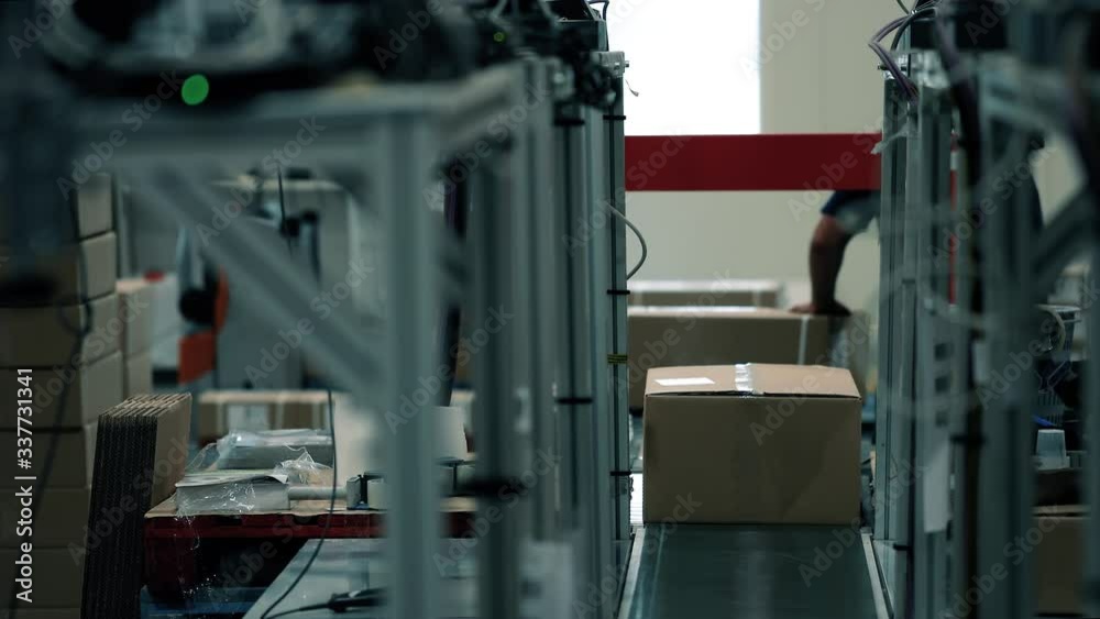 Parcels are picked up by operators on the packaging line in a warehouse. Parcels wait on the conveyor to be shipped. Automation of online shipping logistics Parcels are picked up by operators on the packaging line in a warehouse. Parcels wait on the conveyor to be shipped. Automation of online shipping logistics