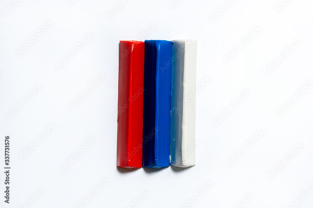 Three multi-colored plasticine bars on a white background. material for children's creativity. isolate.
