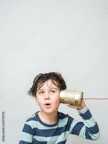 Little boy holding a can with a cord