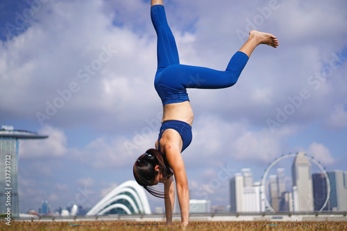 Sporty Asian Chinese Female Yoga practioner exercising under the sun photo