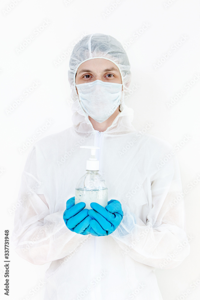 A man in a protective suit holds an antibacterial antiseptic gel for hand disinfection. Health care prevention during an outbreak of the flu virus and a coronavirus epidemic