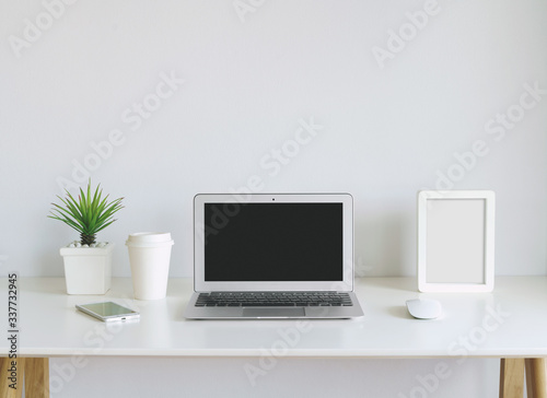 modern lap top template mock up on white and clean work desk with blank screen © tanatat