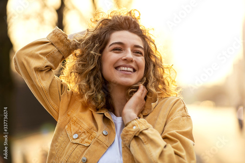 Portrait of young woman with curly hair in the city
