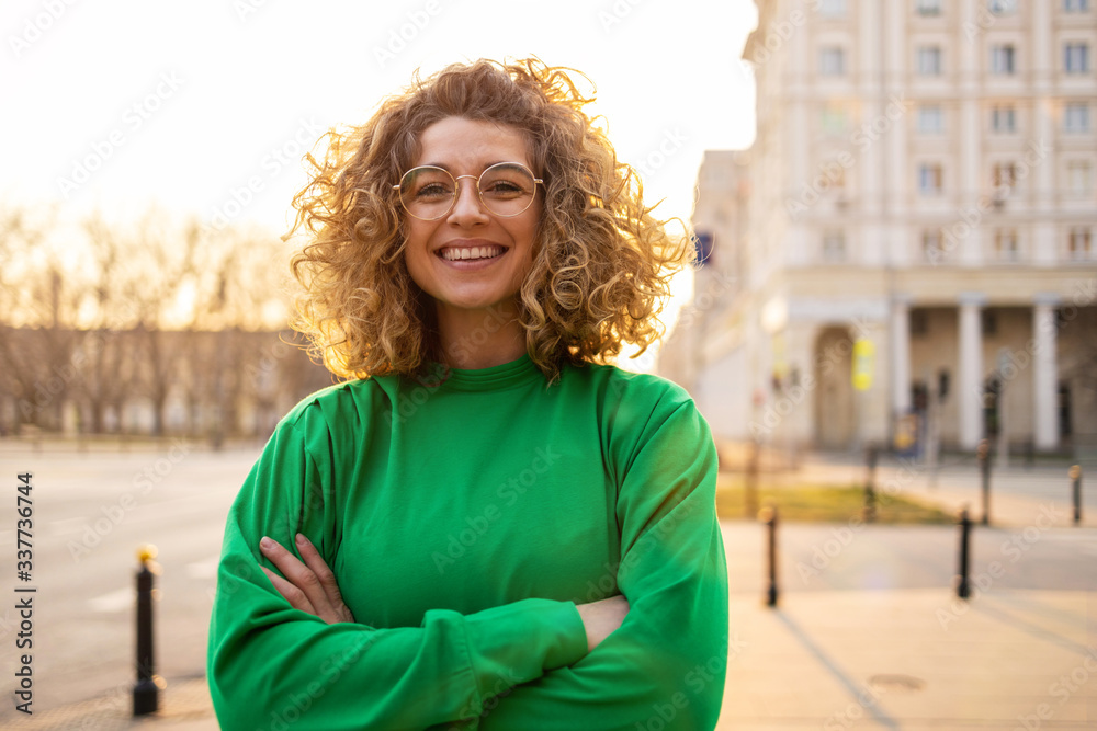 © pikselstock - Portrait of young woman with curly hair in the city