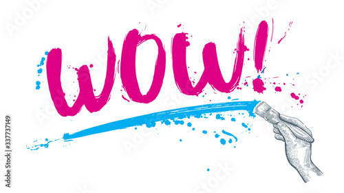 Hand writes the word "WOW" using brush and paint