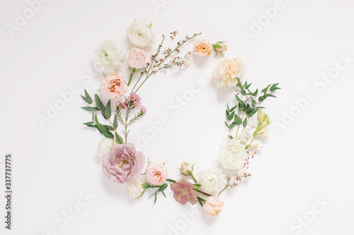 Round frame wreath pattern with fresh flower buds, branches and leaves isolated on white background. flat lay, top view.