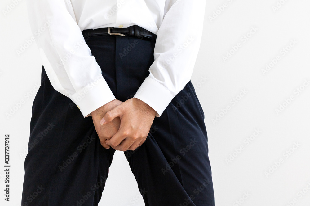 股間を押さえるワイシャツを着た男性
