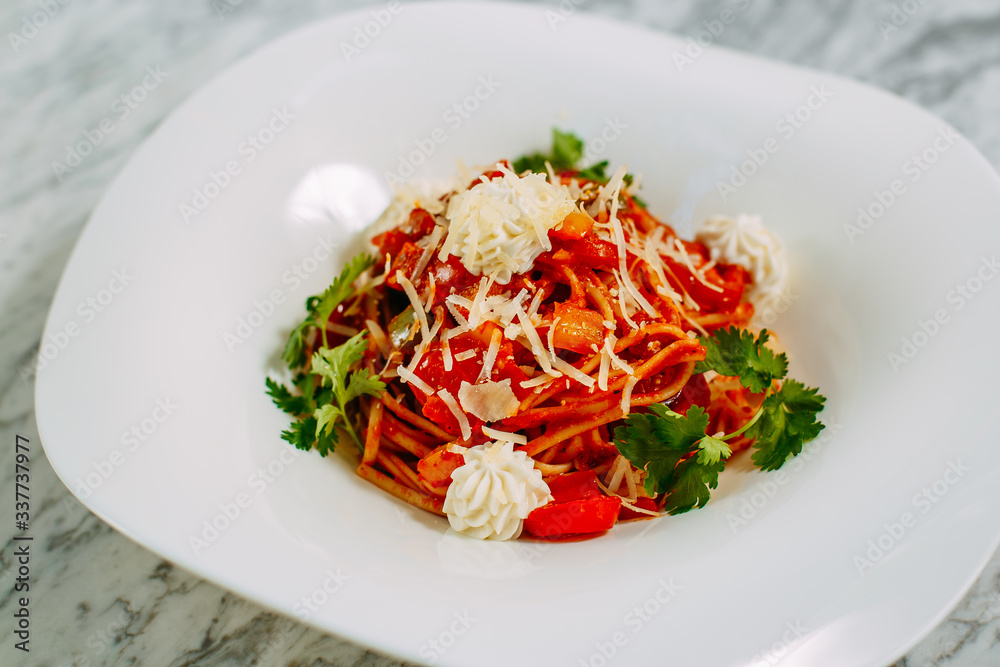 Italian spaghetti with cheese and herbs on a marble table Italian spaghetti with cheese and herbs on a marble table