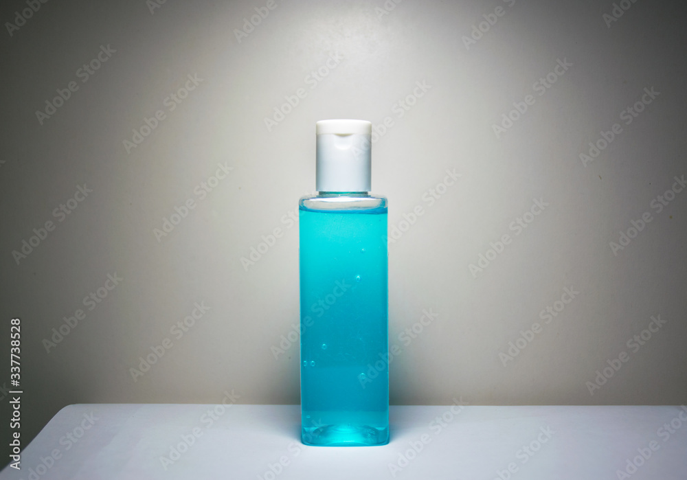 Bottle of hand sanitizer gel required for Coronavirus infection prevention placed on a white table and a white background Bottle of hand sanitizer gel required for Coronavirus infection prevention placed on a white table and a white background
