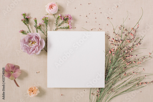 Fotografie Empty white paper blank, flowers, branches on beige background