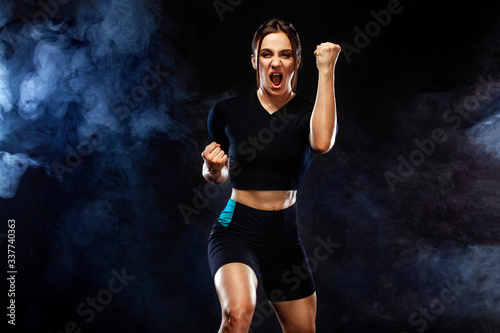 Sprinter and runner girl. Running concept. Woman running on the black background. The concept of a healthy lifestyle and sport. Woman in sportswear.