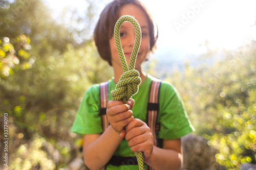 Φωτογραφία A child learns to knit the safety knot from the rope.