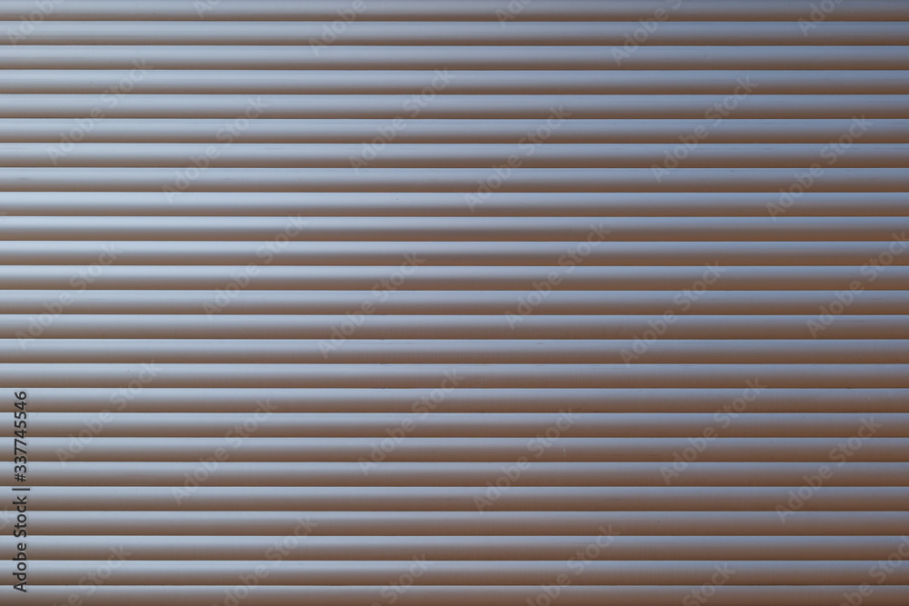 White metal with horizontal linear stripe pattern of rolling shutter door. White metal with horizontal linear stripe pattern of rolling shutter door.