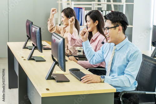 Call center, selective focus of happy smiling call center business team with hands above heads in office, Office and business concept.