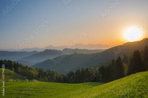 Slovenian breathtaking landscape at sunrise and Julian Alps in the background  in spring. Beautiful misty morning in the mountains in Slovenia.