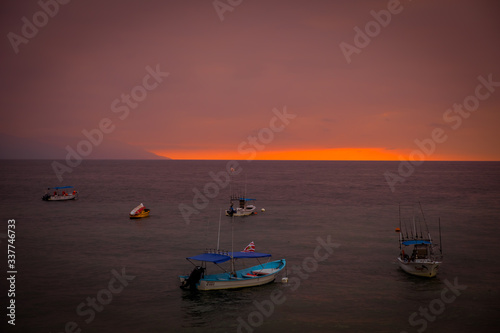 Boats at at a sunset on Puerto Vallarta beach.
