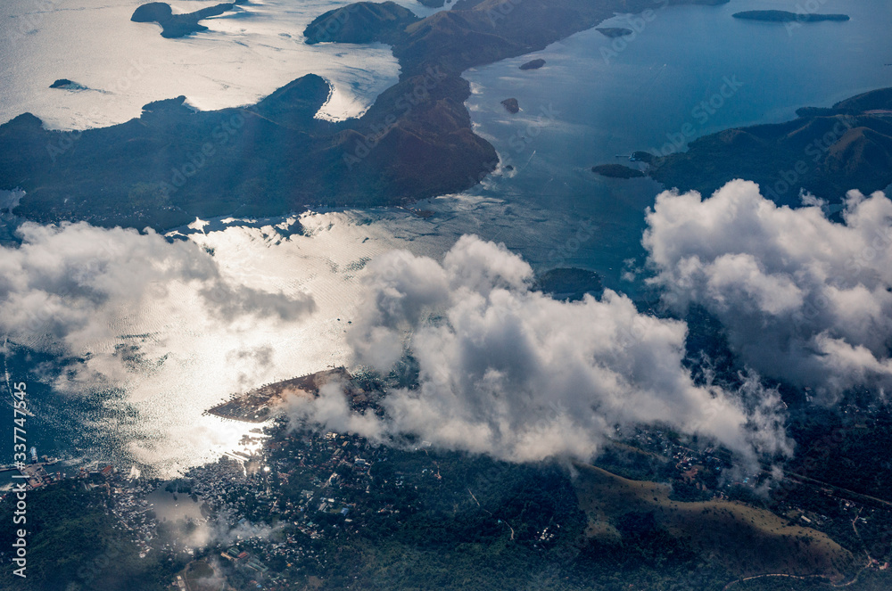 Fototapeta premium Coron Island seen from a plane window above the clouds in Philippines