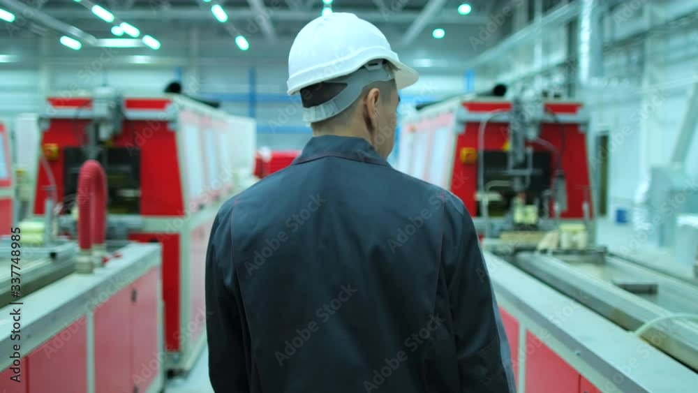 Follow footage of professional Korean, Asian male engineer man in hard hat walking in industrial manufacturing facility on engineering background manufacture plant indoors, worker architect slowmo 4 K