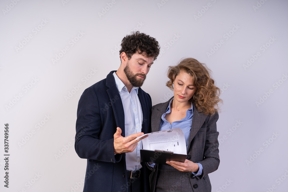 Business man and woman looking at documents, they're working, serious, focused Business man and woman looking at documents, they're working, serious, focused