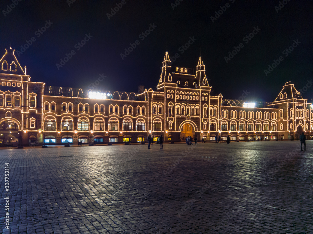 Evening view of the GUM with illumination from the side of an empty red square as a symbol of quarantine