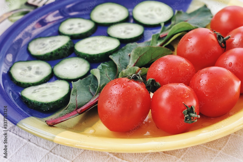 Dietary food background: vegetable salad with cherry tomatoes and cucumbers, vegan cuisine