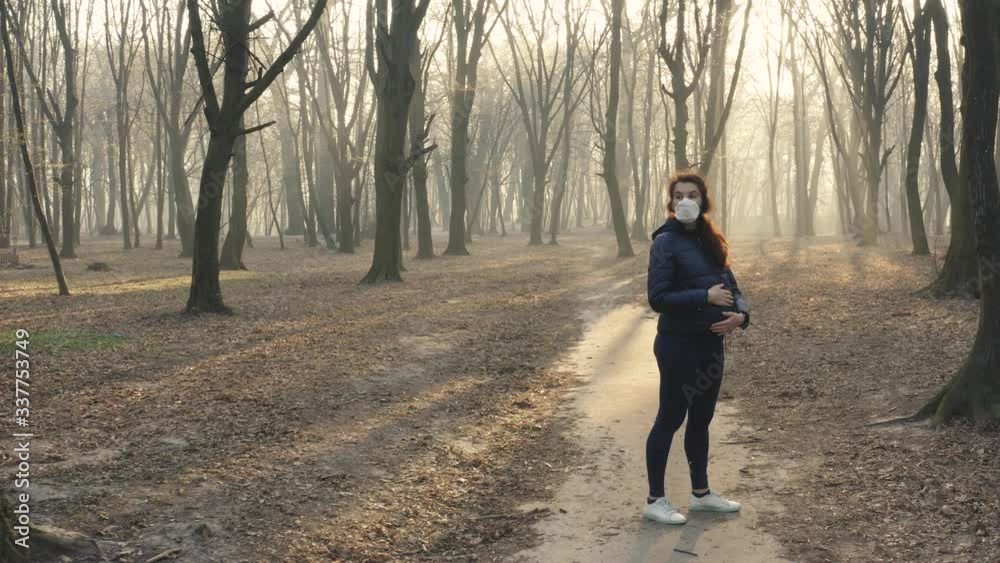 Dolly stedicam shot of pregnant woman in face mask in the woods. Toxic smoke or fog in the forest at sunset. Ecology, environmental pollution concept. Aerial footage 4k Dolly stedicam shot of pregnant woman in face mask in the woods. Toxic smoke or fog in the forest at sunset. Ecology, environmental pollution concept. Aerial footage 4k
